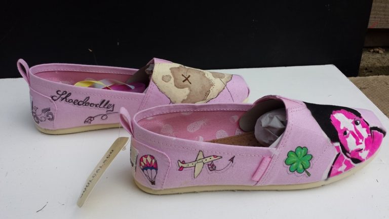 a side view of some pink toms with a travel themed design