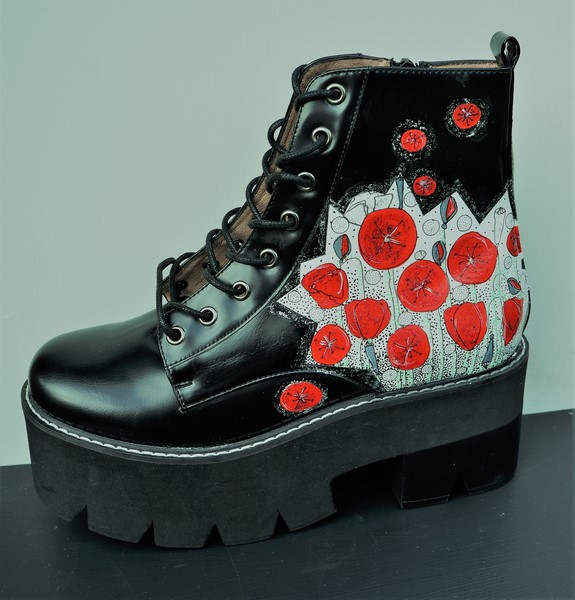 a platform black boot with some stylised poppies on them