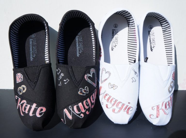 a black pair of Toms shoes and a white pair. Both have the names Kate and Maggie on them, some hearts and a diamond. They were designed for a wedding.
